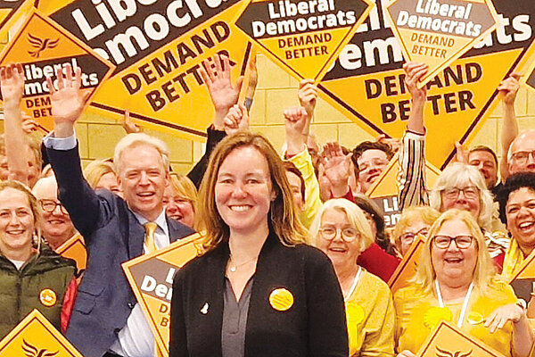Marie Goldman stands in front of a crowd of Liberal Democrat supporters.
